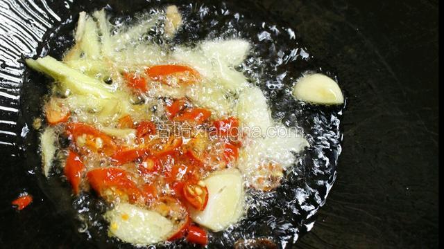 热锅下油，放入姜丝、红尖椒、大蒜，爆出香味