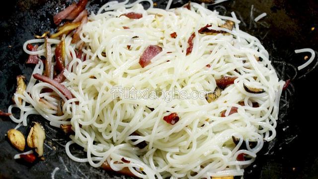 待叉烧香味四溢时，放入干米粉翻炒。油一定要足，不然易粘锅