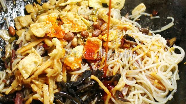 将木耳丝，酸笋、酸豆角、腐竹花生放入锅中，再浇上红油。每次看见这艳丽的红，就忍不住悄悄咽口水~