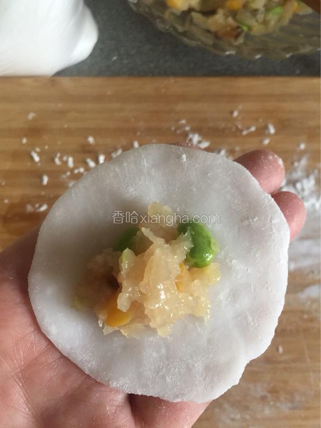 把面按成饺子皮那样大小，中间放上馅儿。