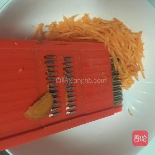 用切丝器将胡萝卜切丝。