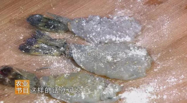 沿着背部切开呈虾扇状，并在虾扇上切花刀，再依次撒上少量盐，白胡椒粉、弹上淀粉，裹蘸鸡蛋液，面包糠。