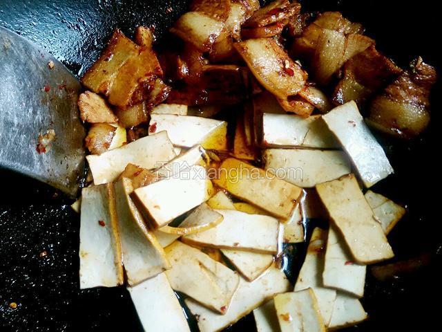 将肉推至一边下香干煸炒小会。
