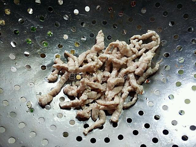 待肉丝变色，调微火，用漏勺把肉丝起锅备用