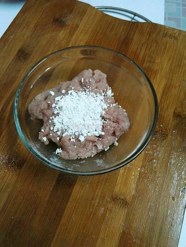 处理好的肉糜倒入干净无水的碗里，倒入适量红薯面粉。