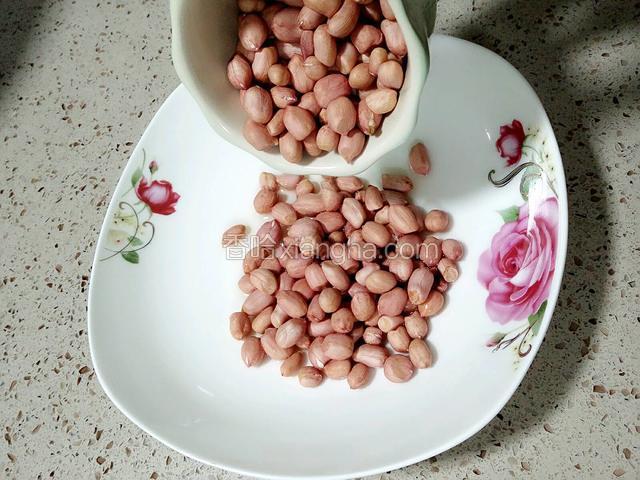 准备一个微波炉专用盘子到少许的油均匀地刷在盘子底部，再到入花生用筷子拌匀，让每粒花生都能用油包裹着。