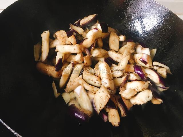 再倒入腌制好的茄子，翻炒至茄子变软。可以倒一点清水闷一下。