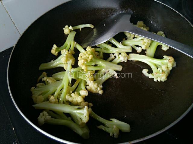 下花椰菜快速翻炒一分钟，注意火不要太大，否则易焦。