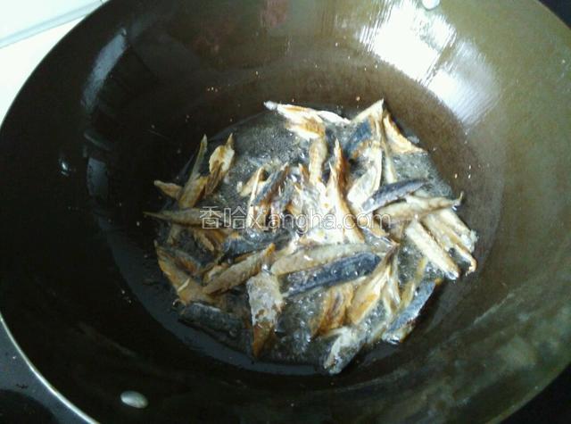 用锅里余油煎鱼干（如油不够了则加点）。