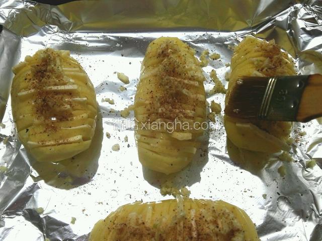 把土豆放入垫了锡纸的烤盘里，撒上蒜蓉、椒盐、少量盐、用刷子刷上玉米油