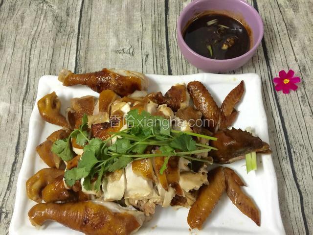 拿个小碗装点酱汁，把鸡按部位切件摆盘，美味的豉油鸡可以吃啦！