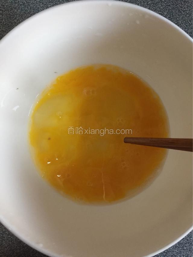 取一块大碗磕入两个鸡蛋，打散。