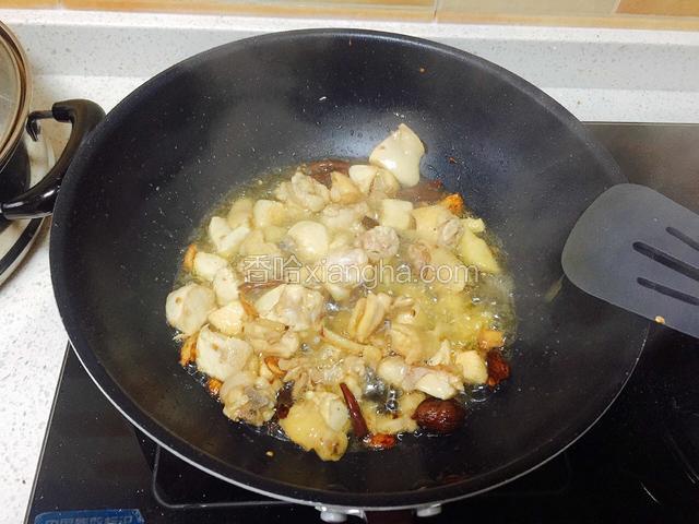 三黄鸡下锅炒至偏黄。