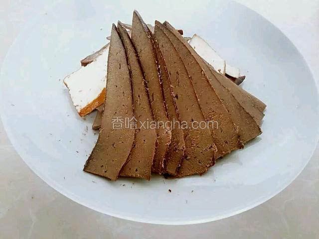 然后开始拼盘，把切过的卤制猪肝，猪肺，豆腐干，切的不是很规则的部分，摆在盘子中间，再把切的比较规范的猪肝片，斜度四十五度依附在中间部分摆放整齐。如图所示；
