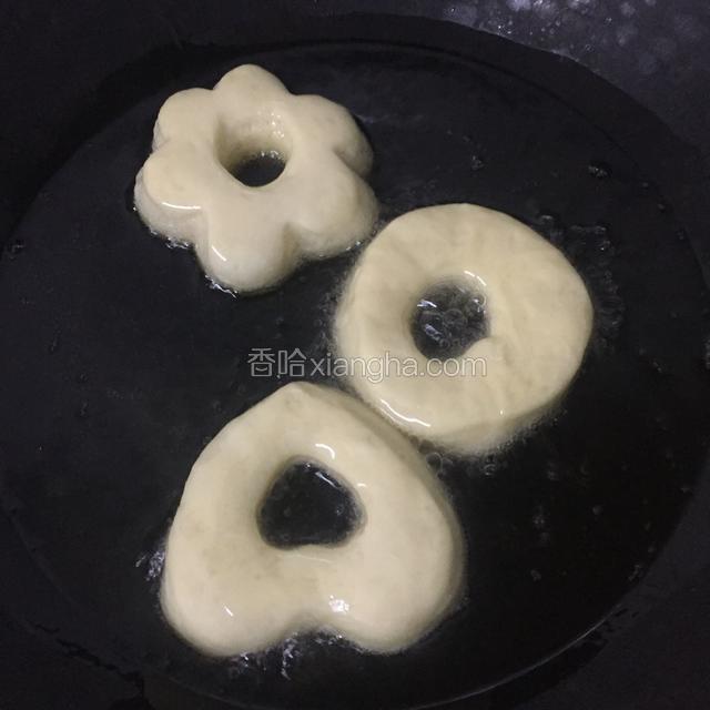 锅内放入色拉油，油温烧至六七成热，放入甜甜圈炸制两面金黄色，一定要小火炸制。