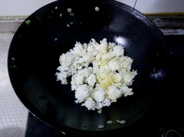 锅里放入少许食用油，倒入米饭炒散。