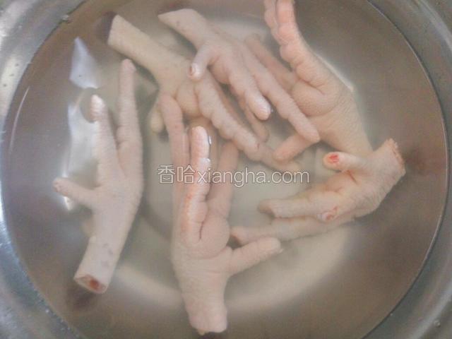 鸡爪放热水中焯烫一下，加一匙料酒去腥。捞出过凉