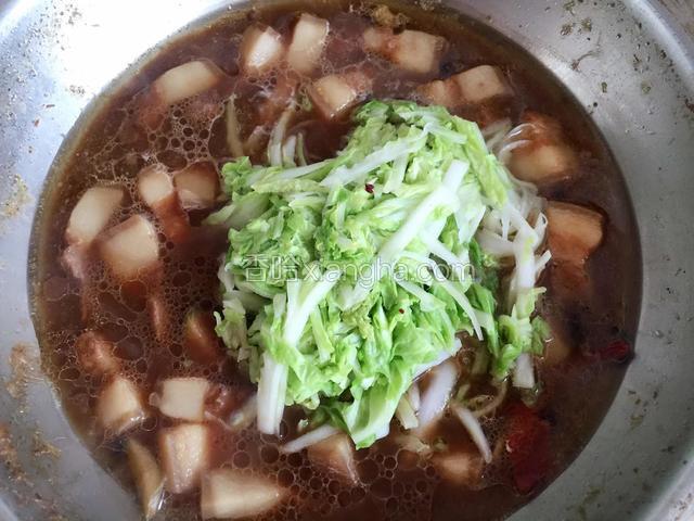 肉块炖煮约一个小时后，放白菜丝，加盐调味。