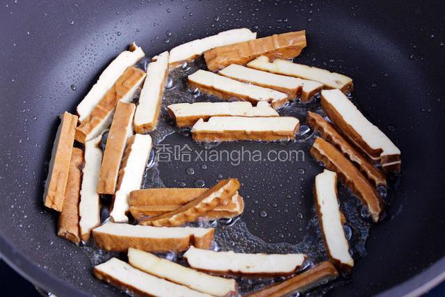 油锅烧热煸炒香干至变色，捞出备用
