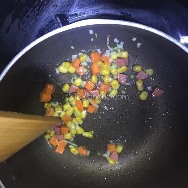 倒入少量油，将胡萝卜，火腿肠，玉米炒香