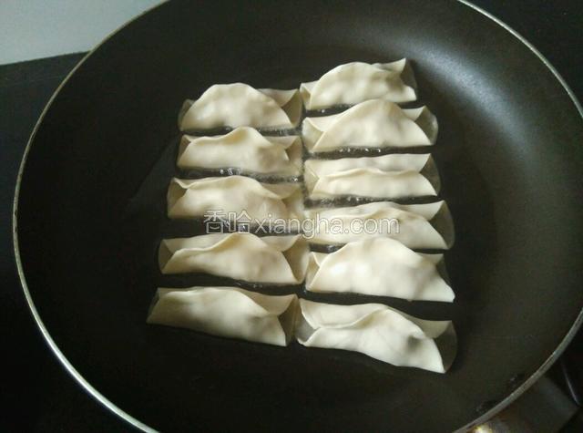 把锅贴逐个放入油锅。