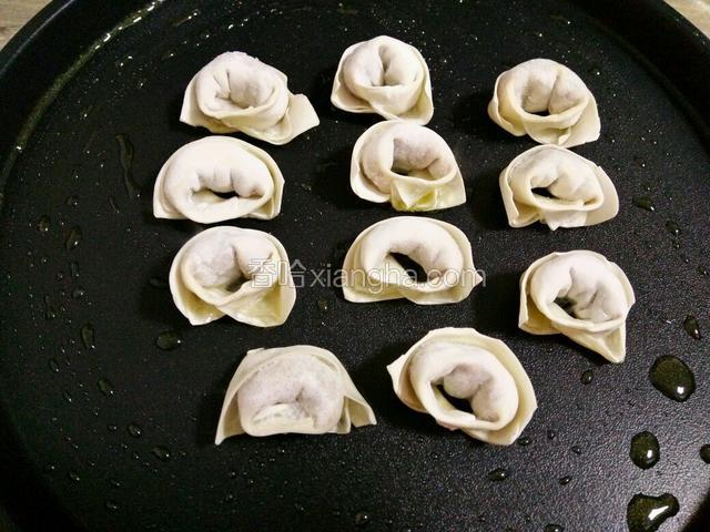 把油推开均匀，放入馄饨，小火煎（电饼档的朋友按烙饼键）