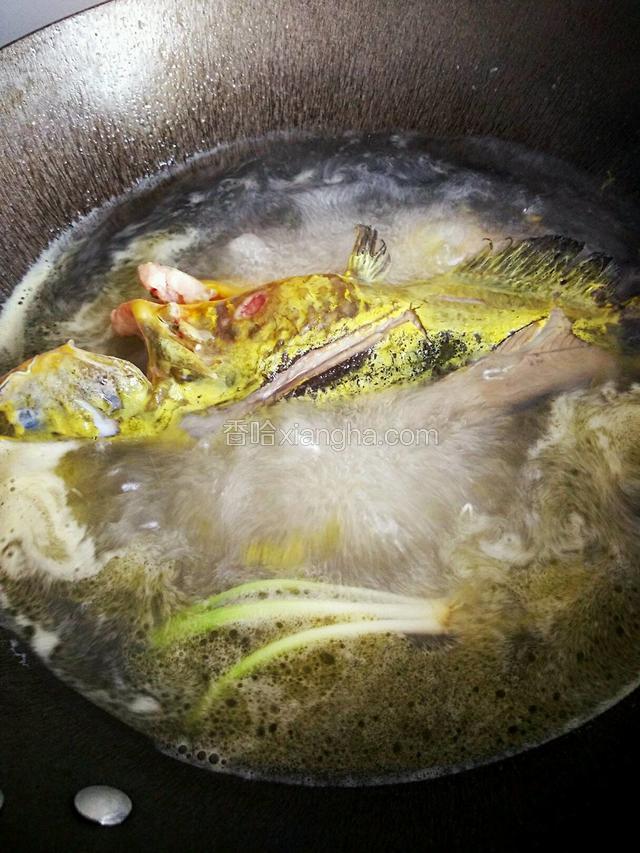 两面煎黄，加入足够量的开水，大概能淹没鱼身，同时放进姜和葱白