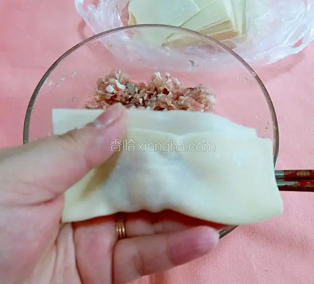 第二步，将包上虾肉馅的馄饨皮对折。