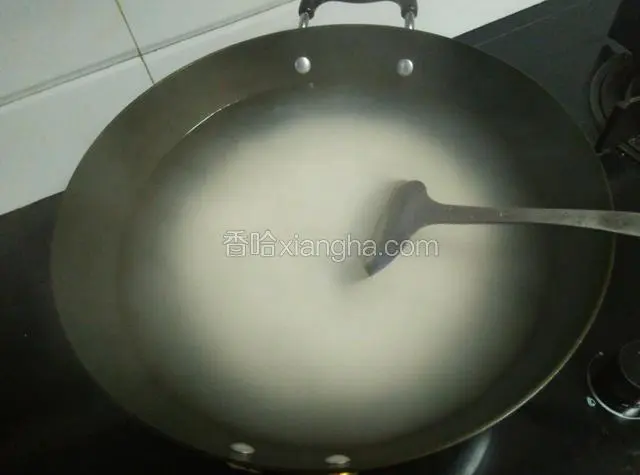 倒入大米，用锅铲铲动锅底，防止糊锅，直到再次开锅。