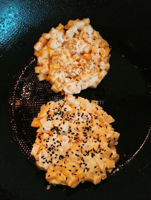 用铲子按扁表面撒上芝麻