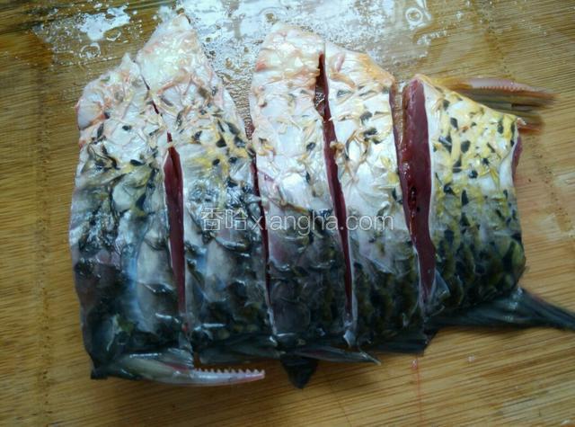 把鲤鱼洗净，挑去腥线，撕去黑膜，切块。