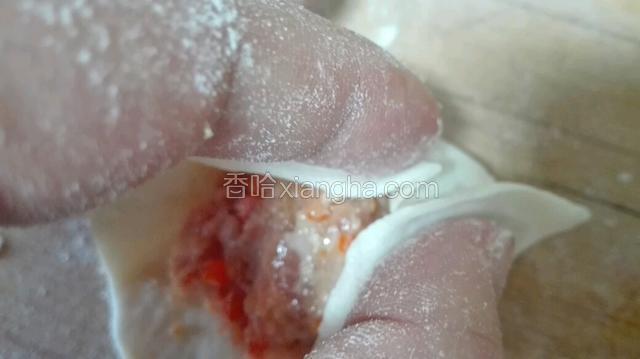 再稍微往左边一点，把饺子的上部分往右再捏一个小褶，依次把上面的饺子皮往右捏完，可以多捏几个小褶皱，比较好看