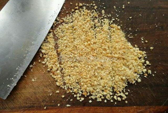 花生米去皮，用刀背碾压成碎丁；