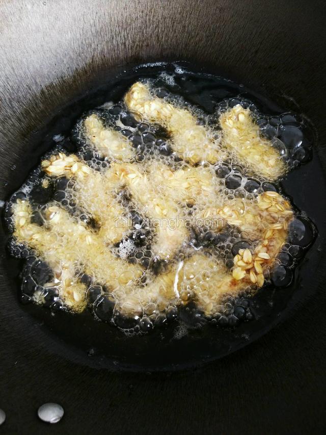 热锅倒油，烧至七成热时转小火，依次放进裹好的肉条