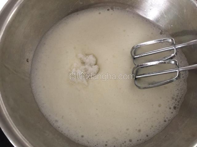 在蛋白里滴人柠檬汁，用电动打蛋器打至细泡加入20克白糖，继续打发。