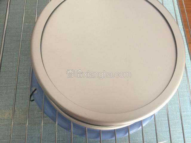 把烤好的蛋糕从烤箱里取出来在桌子上震两下，立即倒扣在烤网上晾凉，就可以脱模。