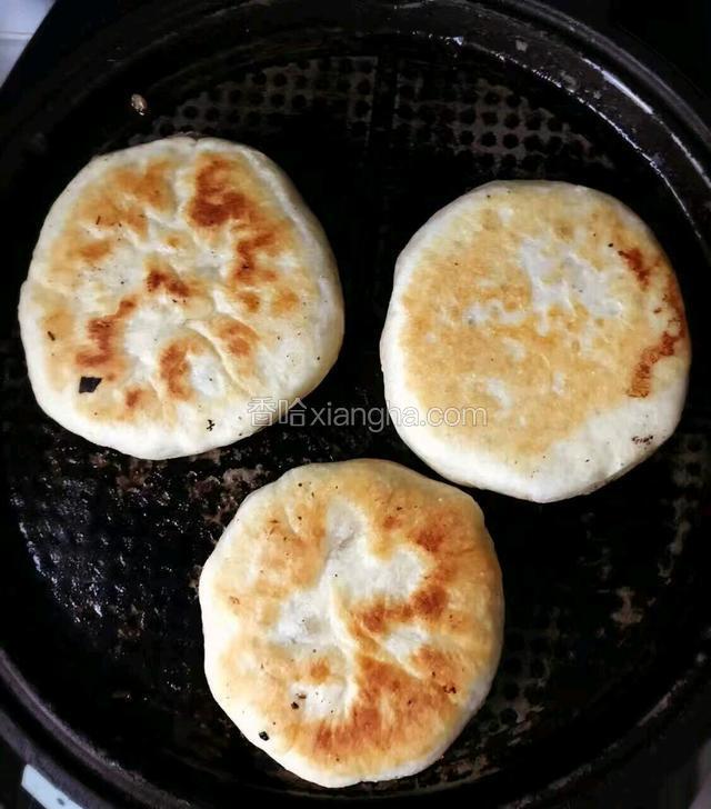 烙火烧。打开电饼铛，预热，并抹好油，将火烧胚子放进去，待到一面成金黄色时，翻动，烙另一面，最后将火烧立起来烙一下火烧周围。