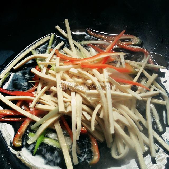 起油锅，把香干，红椒，葱一并放入