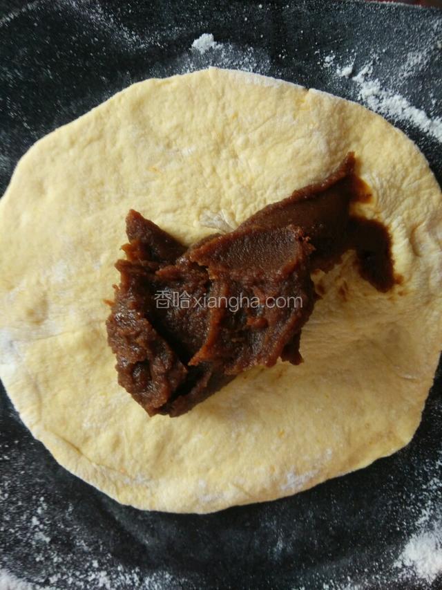 把豆沙馅放在擀好的剂子中