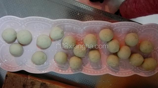 手上沾上水，将红薯面，团成小球。