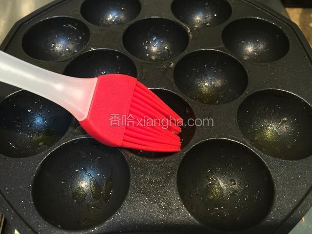 用刷子将章鱼烧盘刷上一层油