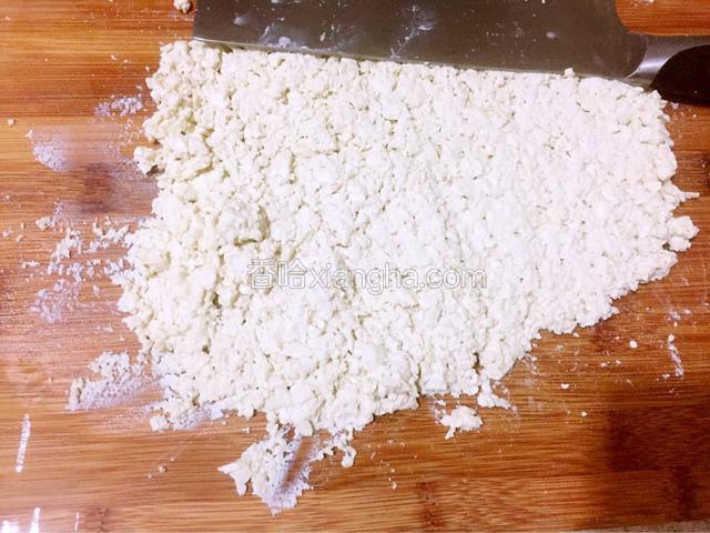 豆腐用刀切成小块，再用刀面压碎豆腐