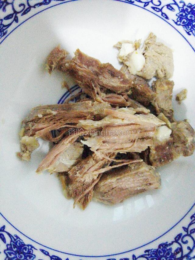 羊肉炖好捞出，用水撕成条或切成薄片
