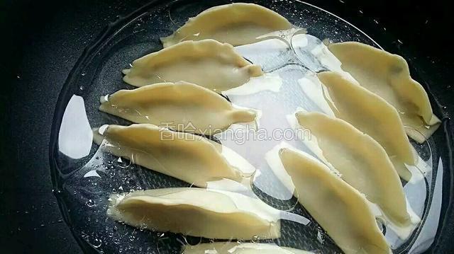 接着往锅内加适量的清水，水的量~把饺子半淹没即可