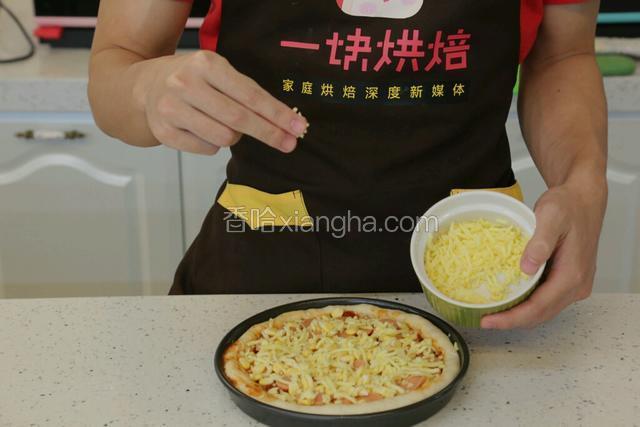 继续铺上二分一的马苏里拉芝士，加热后都可以化掉。再陆续铺上玉米、香肠，如果有蔬菜，就再铺上蔬菜。在披萨外圈可以刷一圈蛋黄，或者一圈色拉油。烤出来颜色好看诱人