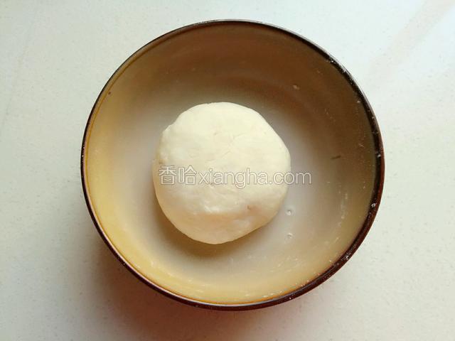 把水油皮材料倒入碗中混合(中筋面粉+猪油+糖+水)，用手揉成一个光滑的面团。