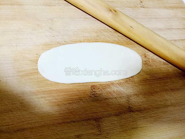 取一个面团，将其擀成牛舌状。