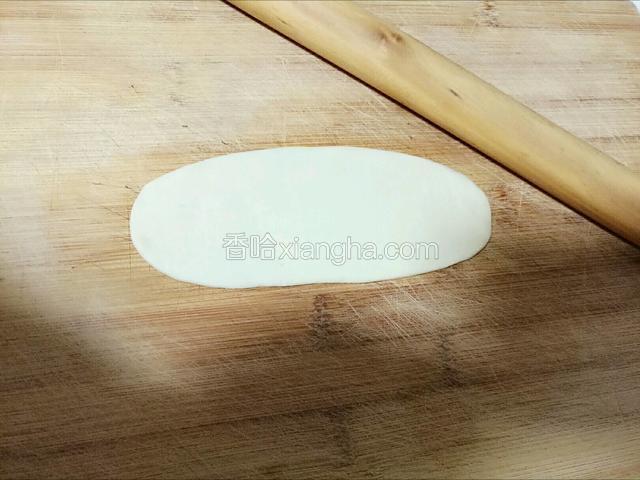 取份松弛好的面团，将其顺方向擀长。