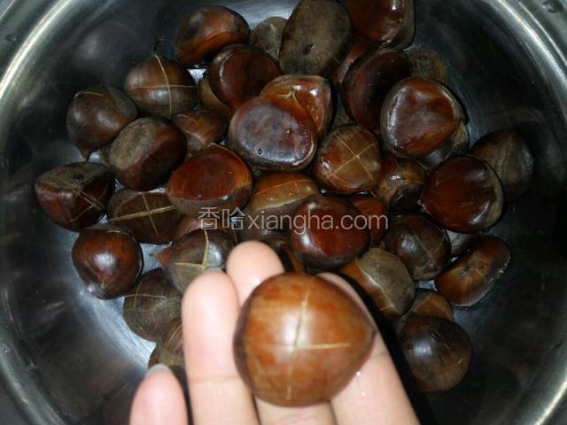 在板栗的凸起处，用刀划十字口。这个过程尽量小心，可放在案板上划，不要伤到手吆
