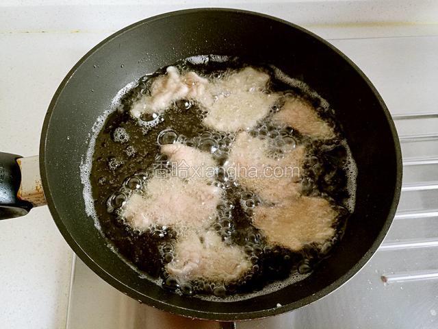 将肉片一片片展开放入锅中，炸至五六成熟时捞出。
